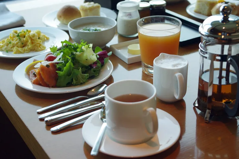 Table de petit-déjeuner avec jus d'orange, café et viennoiseries