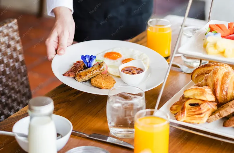 Service de petit-déjeuner à l'hôtel avec viennoiseries et jus d'orange