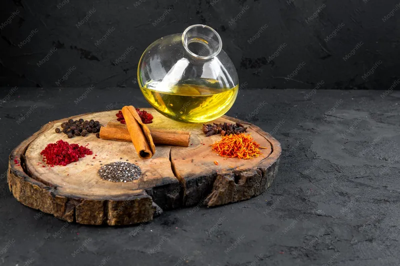 Carafe d'huile et épices (cannelle, paprika, poivre) sur un rondin de bois