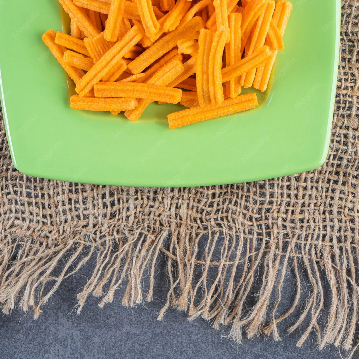 Frites dorées servies dans une assiette sur toile de jute